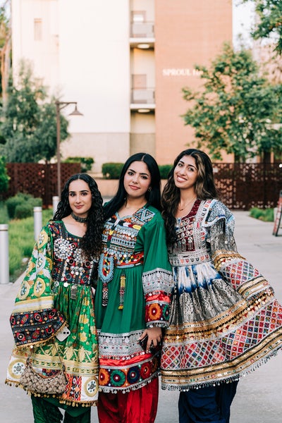 3 girls dressed in traditional afghan dresses